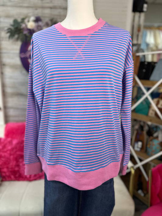 A pink and blue striped long-sleeve crewneck sweater displayed on a mannequin torso, with a pink ribbed collar, cuffs, and hem.
